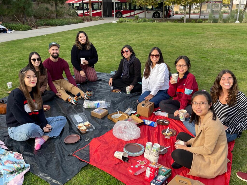 all lab members sitting on blanket outside 